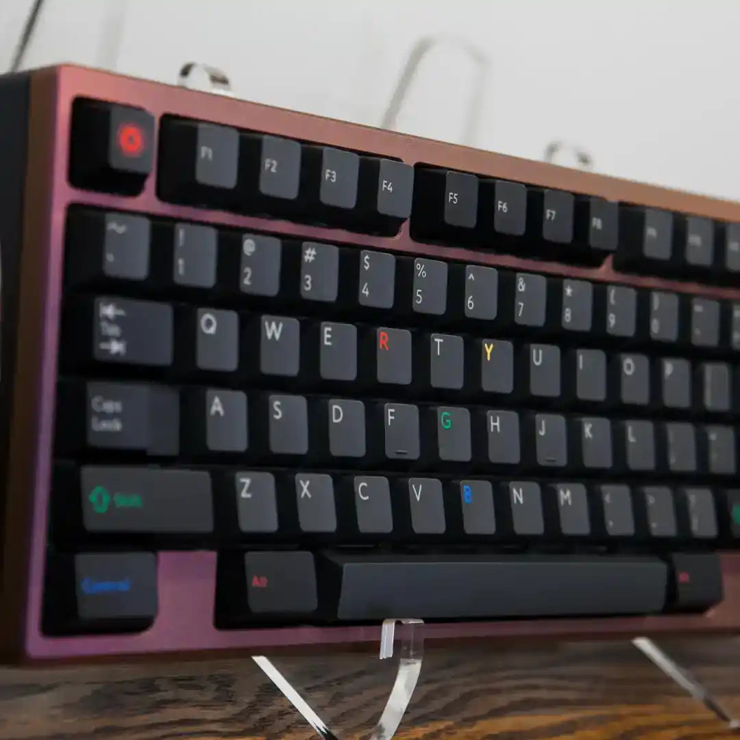 A mechanical keyboard with black keycaps and a reddish-brown metal frame.