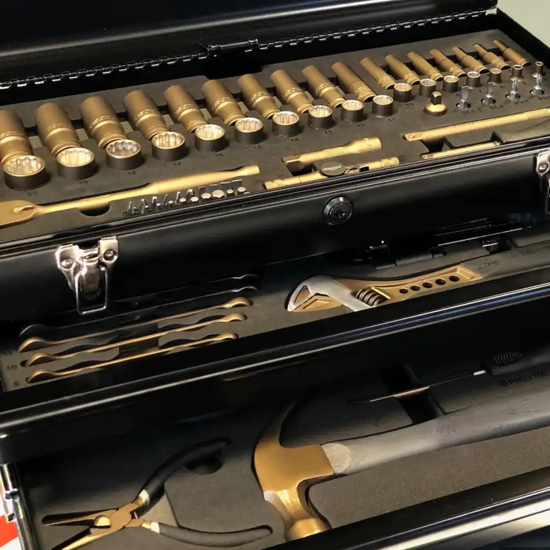 A multi-tiered black toolbox filled with neatly organized gold-colored hand tools.