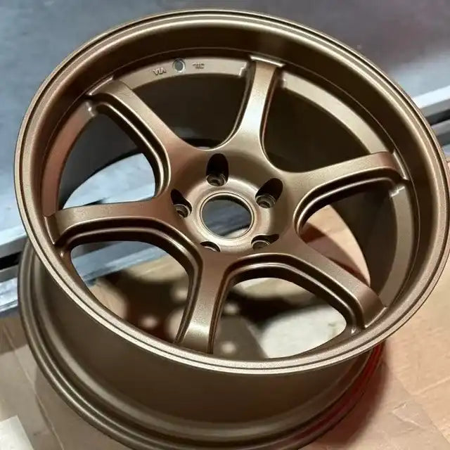A five-spoke bronze alloy wheel with a deep dish.