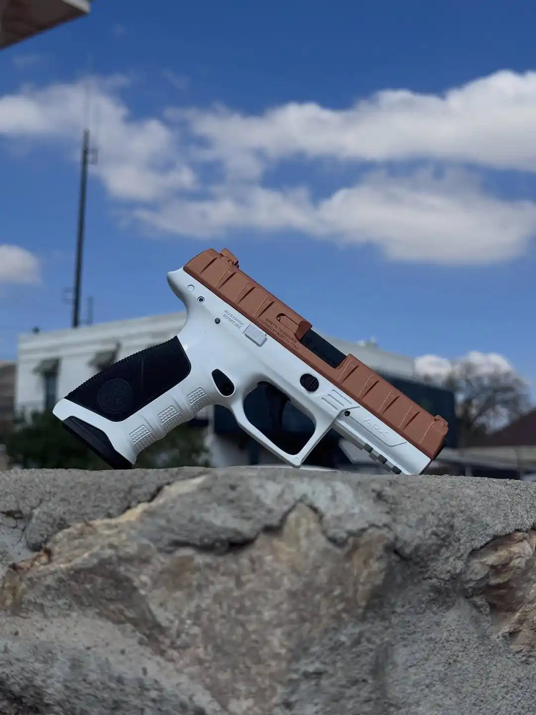 White and brown handgun with black grip, likely a glock model.